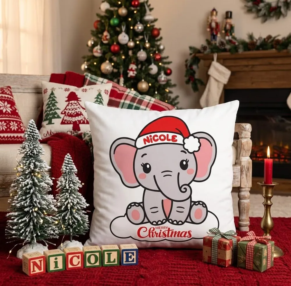 Cuscino bianco con un elefantino col cappello di Babbo Natale e il nome Nicole