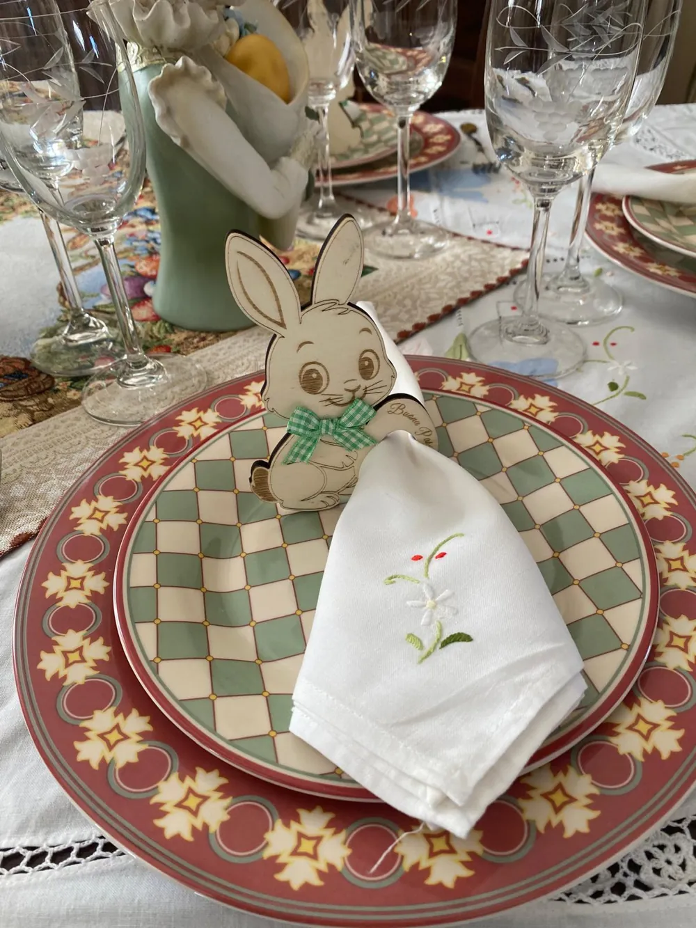 Portatovagliolo in legno a forma di coniglietto su un piatto apparecchiato per Pasqua